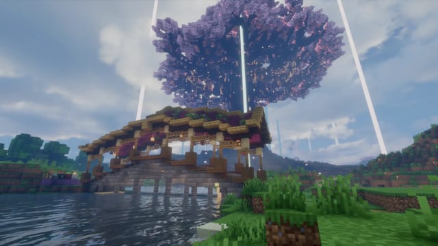 Covered wooden bridge across a river, with the huge cherry blossom canopy of Yggdrasil behind it