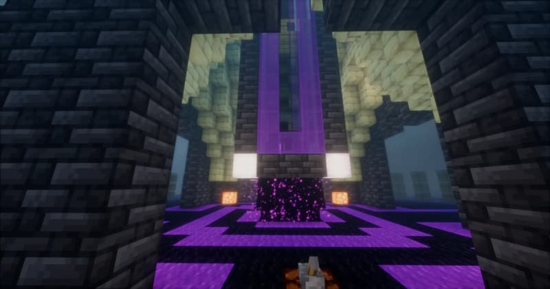View through a dark brick archway onto the base of the tower: an end portal block between two lights, purple glass and end stone above, a purpur-patterned floor in front
