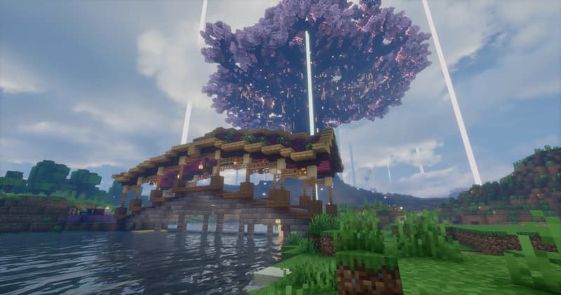 Covered wooden bridge across a river, with the huge cherry blossom canopy of Yggdrasil behind it