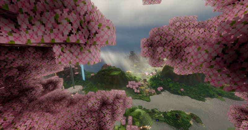 View from inside the cherry blossom canopy across the landscape with a village and a river below
