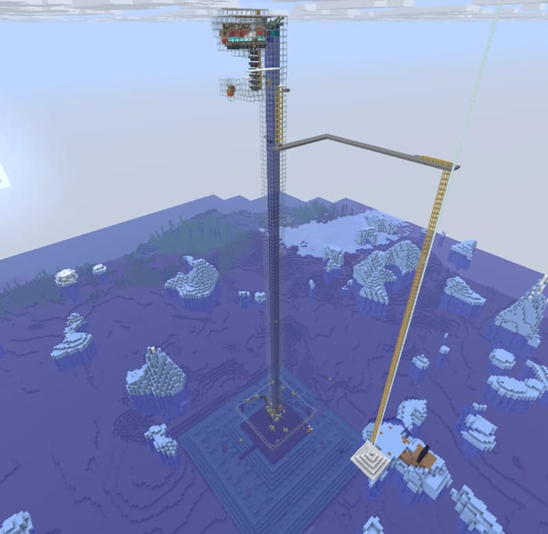 Tall, narrow shaft with a transparent chamber at the top, beside a yellow scaffold and a horizontal arm, surrounded by icy snow formations